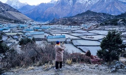 Una persona capturando una fotografía de un pueblo pintoresco.